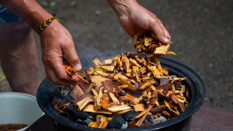 adding wood chips to the fire