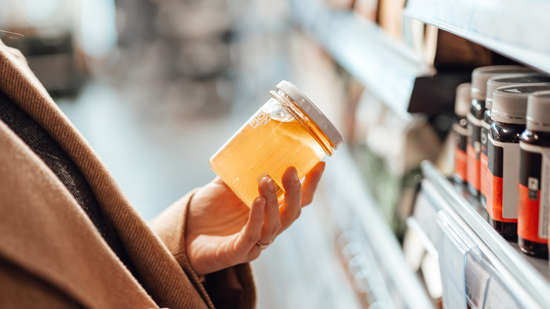 Person holding jar of honey