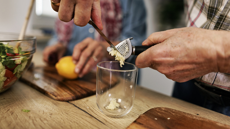 man scraping garlic press