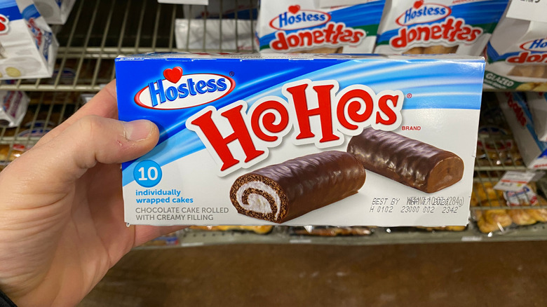 Grocery shopper holding a box of Ho Hos snack cakes