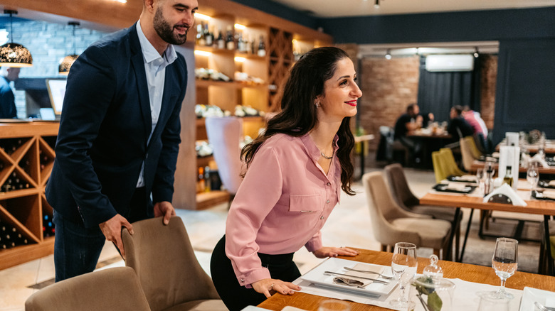 Man helping woman get seated