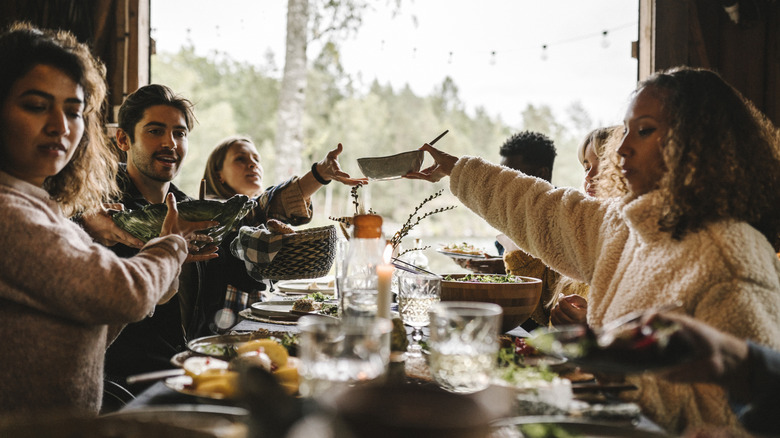 Large dinner party passing dishes