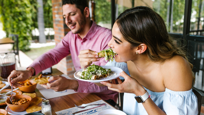 People eating nachos and tacos with their hands