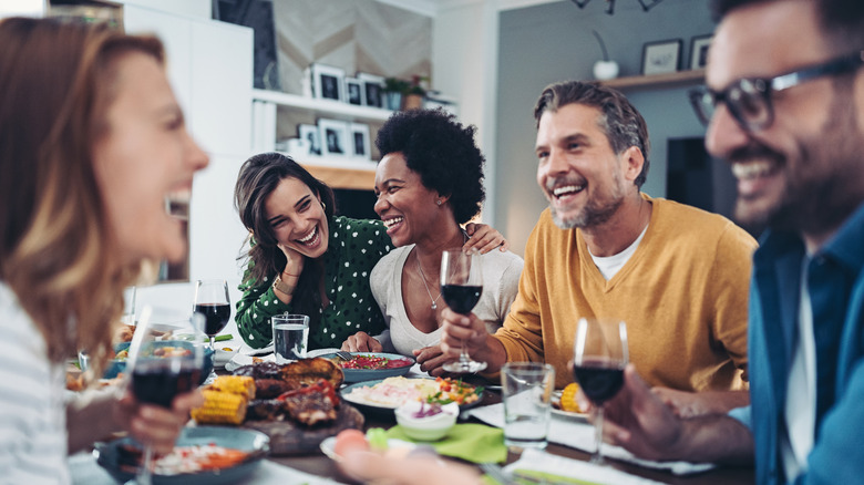 Group of friends talking and laughing while dining out