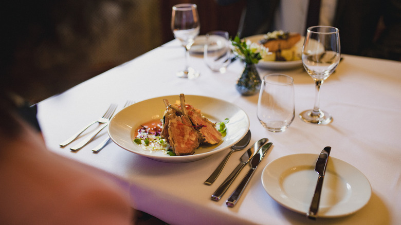 Dinner plate with many utensils on table