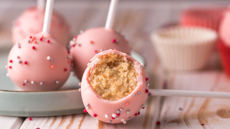 pink cake pop with a bite missing, other cake pops in the background