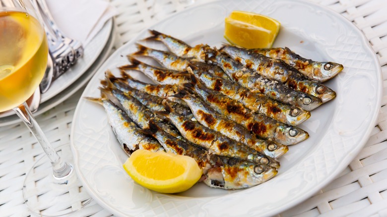 Grilled sardines with lemon wedges