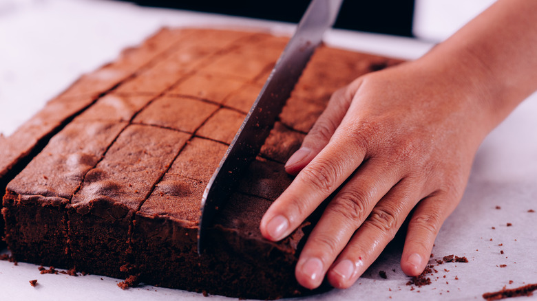 baker slicing cake into squares