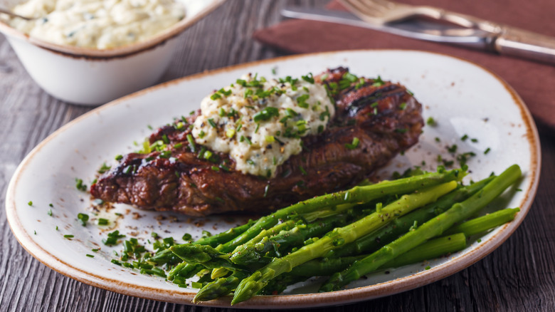 Steak with a blue cheese sauce and grilled asparagus