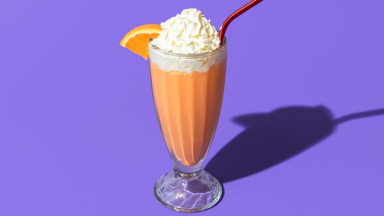 Orange milkshake on purple background