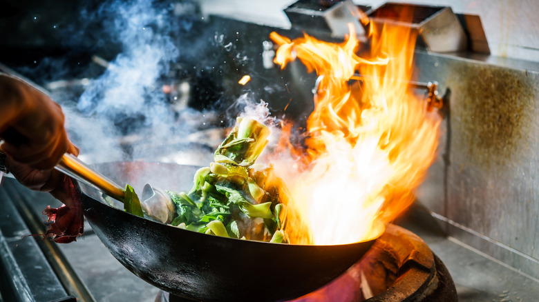 vegetables in wok with flames