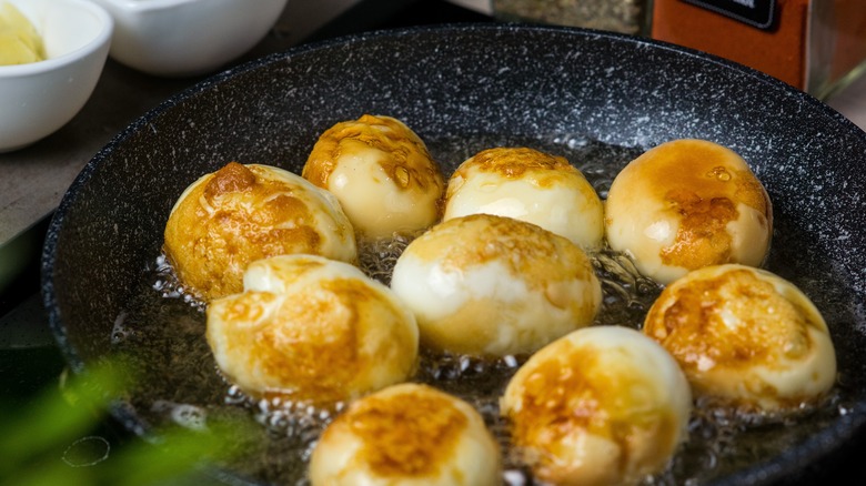 fried hard boiled eggs in a pan