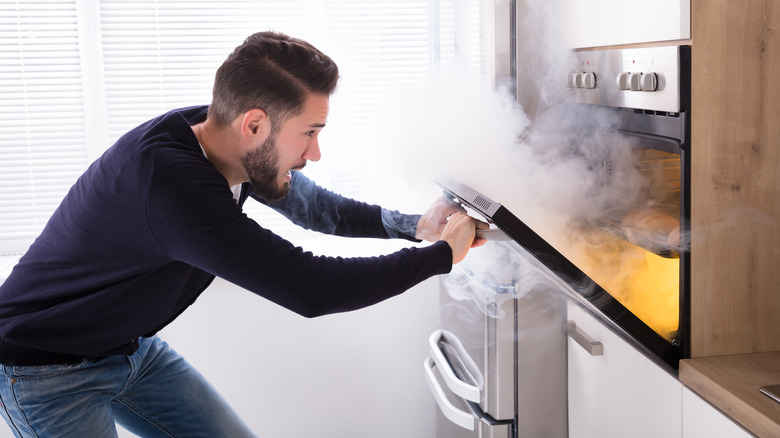 Man opening smoking oven