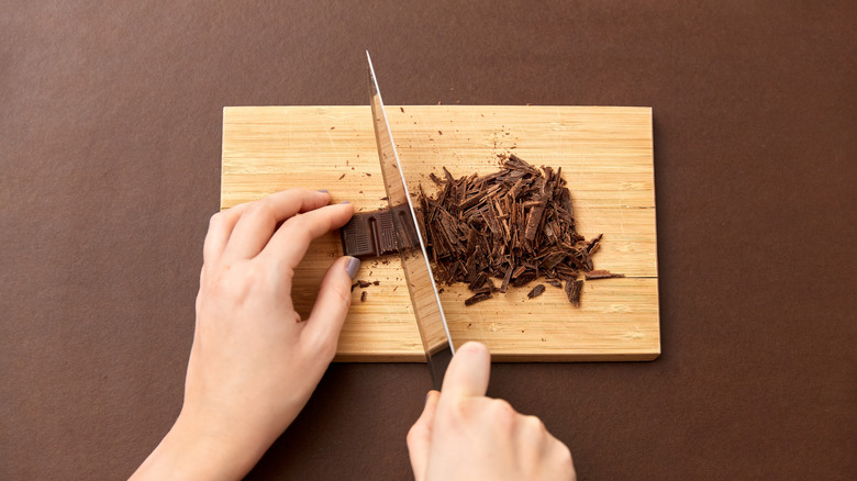 Chopping chocolate bar with knife