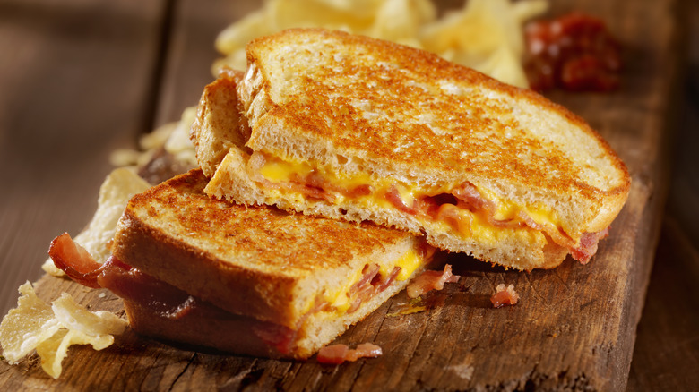 bacon grilled cheese cut in half with chips