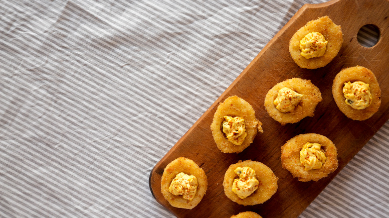 Fried deviled eggs on wooden board