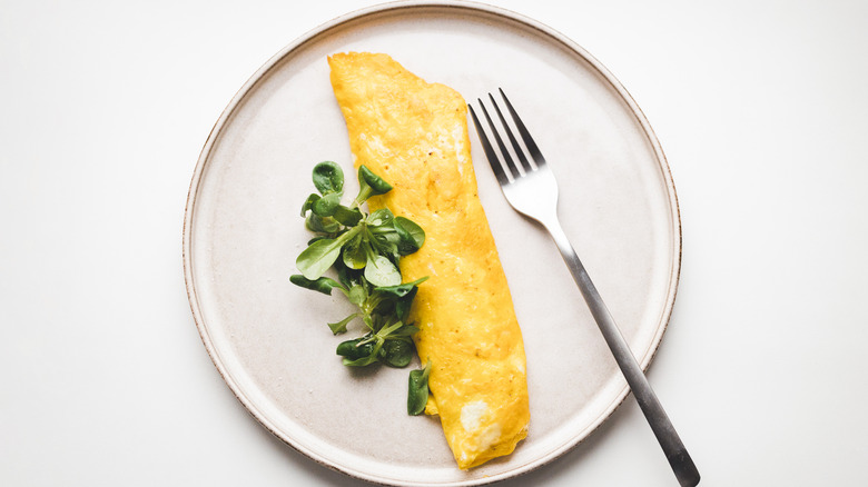 French omelet with greens and fork