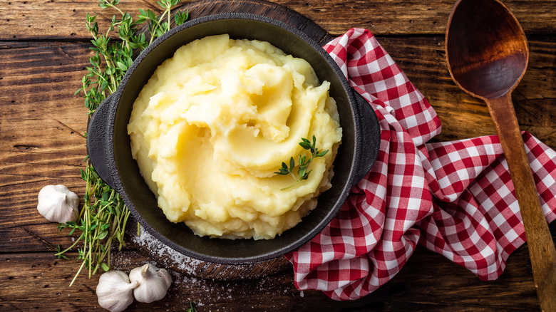 bowl of mashed potatoes and fresh garlic cloves