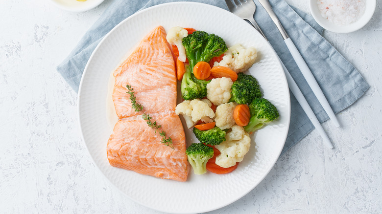 steamed salmon and vegetables on a white plate