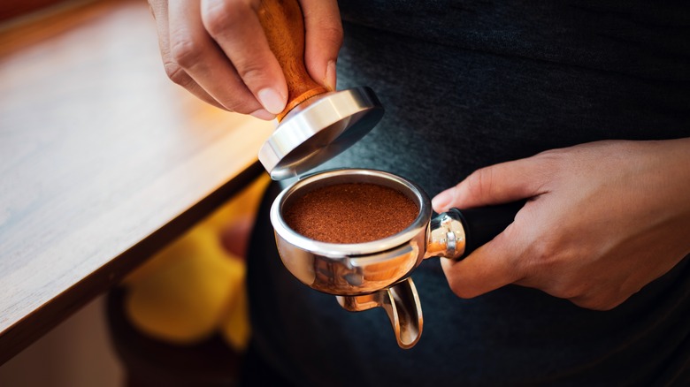 Hands tamping espresso