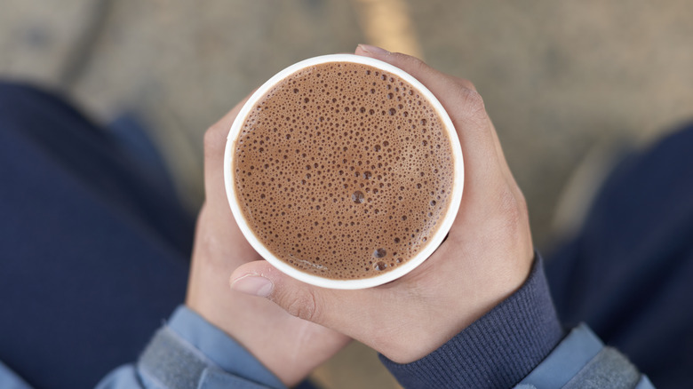 holding hot chocolate in cup