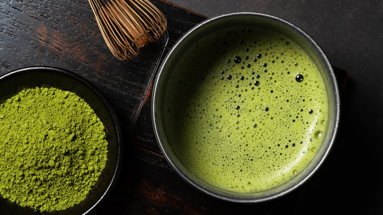 bowl of matcha with whisk and powder