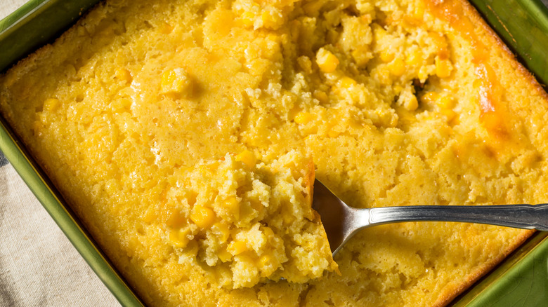 Corn casserole in baking dish with a spoonful scooped out