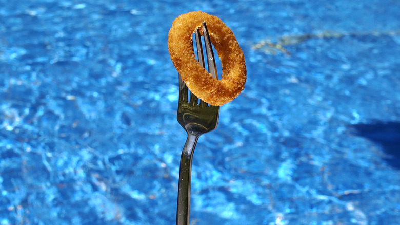 Onion ring on fork water background