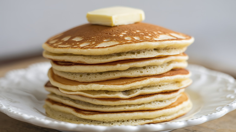 A stack of pancakes topped with butter
