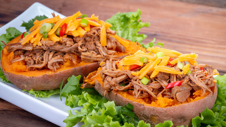 Puled pork filled sweet potato skins with cheese on a plate