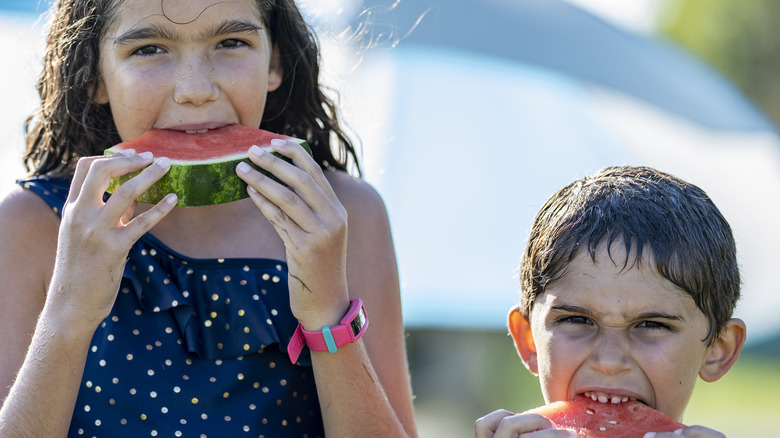 two children eating watermlon slices