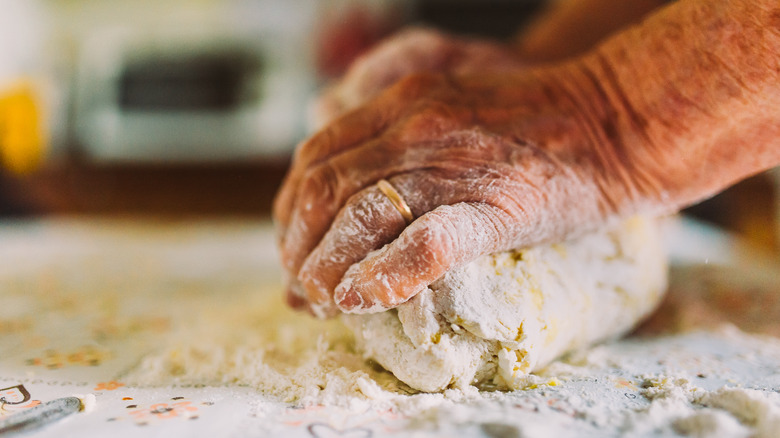 hands kneading dough, ring