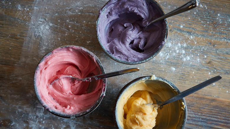 different colored frostings in bowls