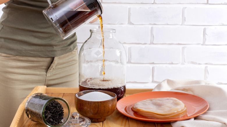 pouring tea into glass jar