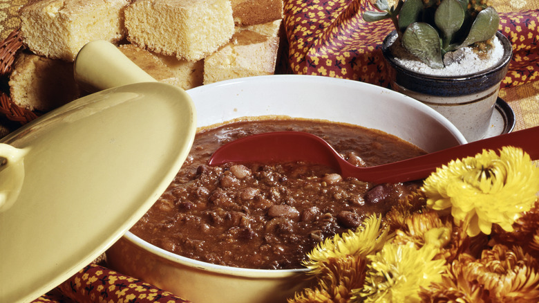 A finished pot of chili with bread on a dining room table