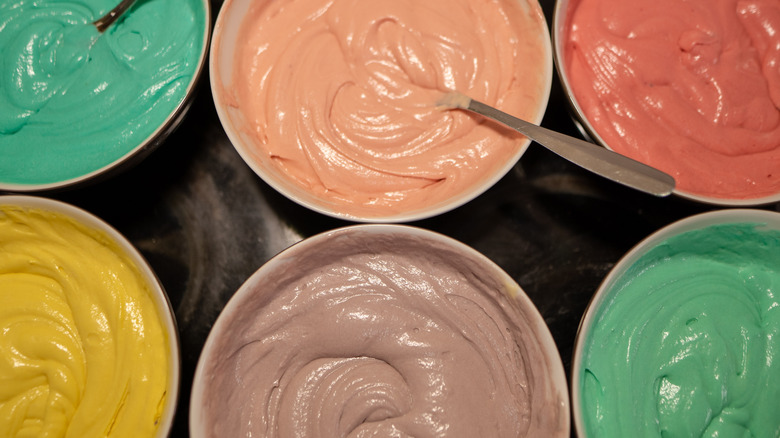 Bowls of teal, pink, red, yellow, purple, and green batter