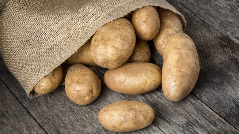 Russet potatoes spilling out of burlap sack