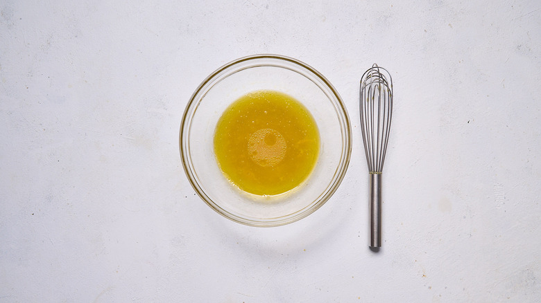 yuzu olive oil dressing in bowl with whisk