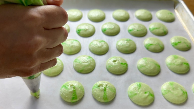 Macarons piped onto baking sheet