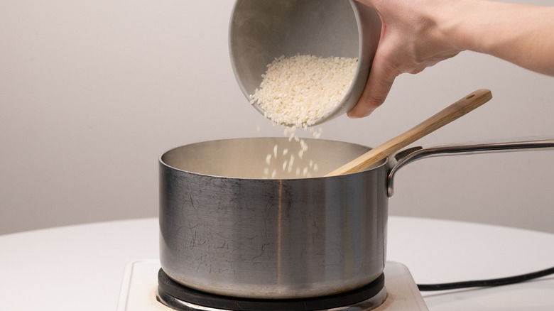 pouring rice into saucepan