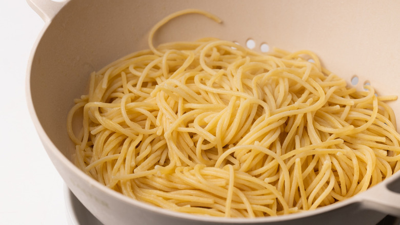Cooked spaghetti in colander 