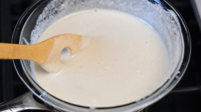 stirring egg whites into honey with wooden spoon
